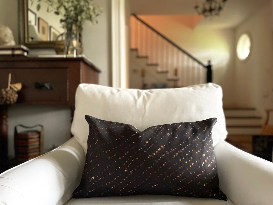 onyx black staccato decolorato shibori pillow in fine linen fabric by the yard on a white chair
