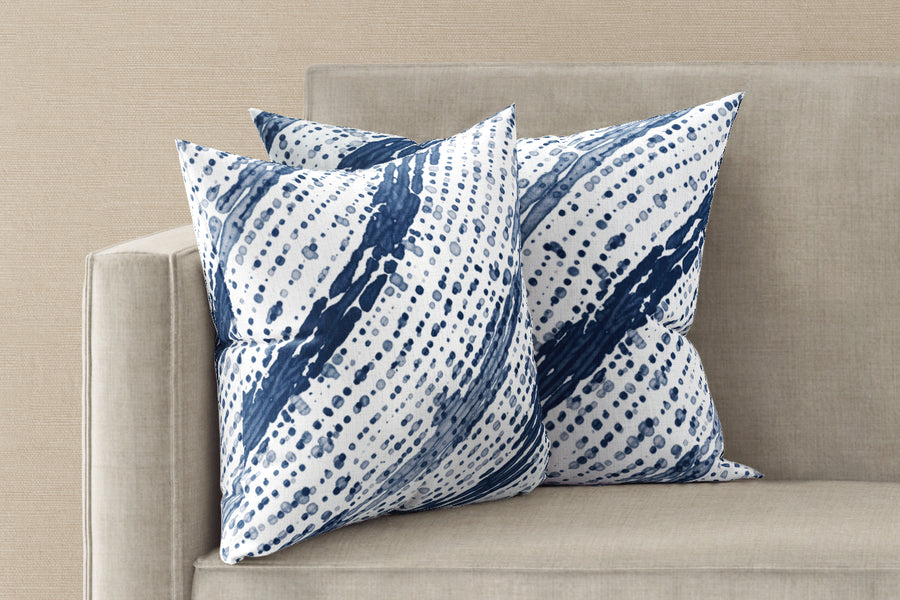 Two 20” x 20” 100% linen reversible glissando shibori pillows in marine blue on a sofa