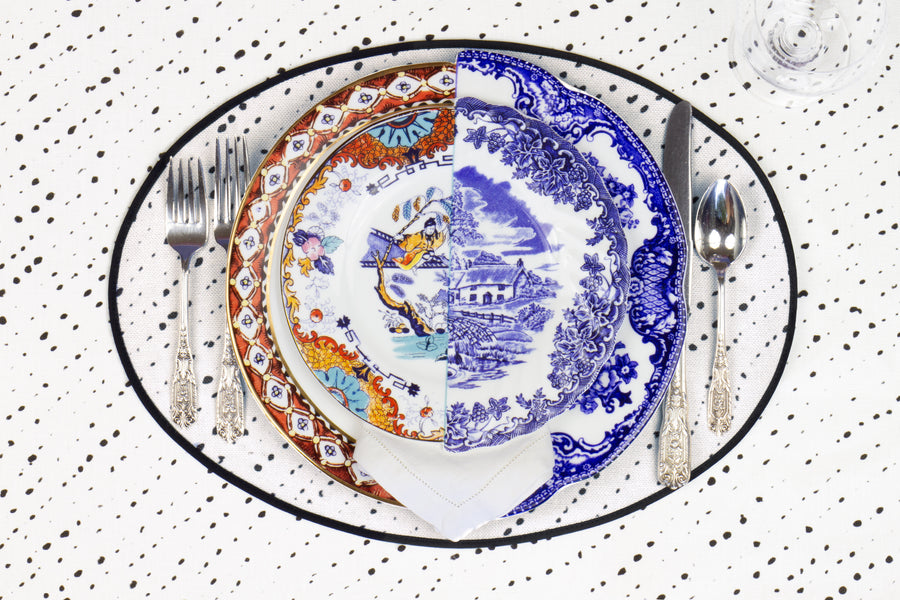 Place setting with 100% linen staccato nero shibori alabaster white placemat on alabaster shibori with colored plates
