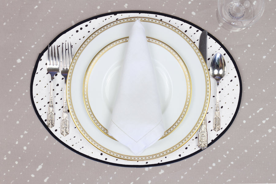 Place setting with 100% linen staccato nero shibori alabaster white placemat on flax shibori linen with white plates