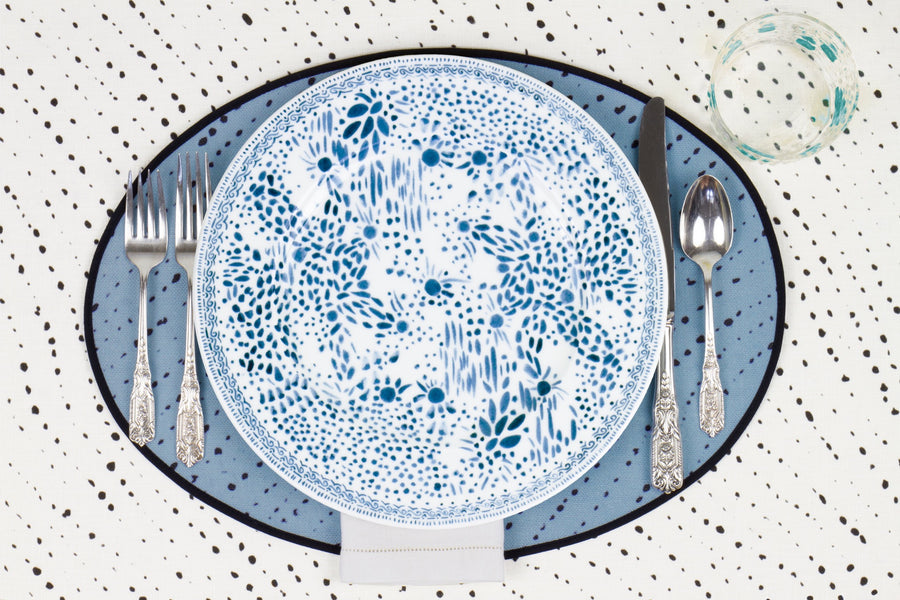 Venable Moore Mosaic Garden dinner plate in fresh blueberry blue with hand-painted Bubble glass on sky blue 'Staccato Neroo' Shibori linen placemat and alabaster white tablecloth with silverware and white linen napkin