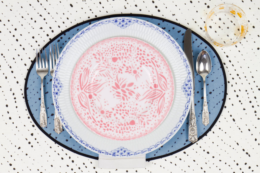 Venable Moore Mosaic Garden salad/dessert plate in fresh grapefruit pink with hand-painted Bubble glass on sky blue 'Staccato Nero' Shibori linen placemat and alabaster white tablecloth with silverware and white linen napkin