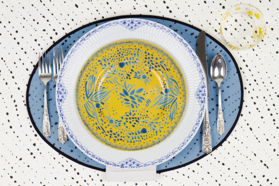 Venable Moore Mosaic Garden salad/dessert plate in lemon yellow on a blue and white plate with hand-painted Bubble glass on sky blue 'Staccato Nero' Shibori linen placemat and alabaster white tablecloth with silverware and white linen napkin