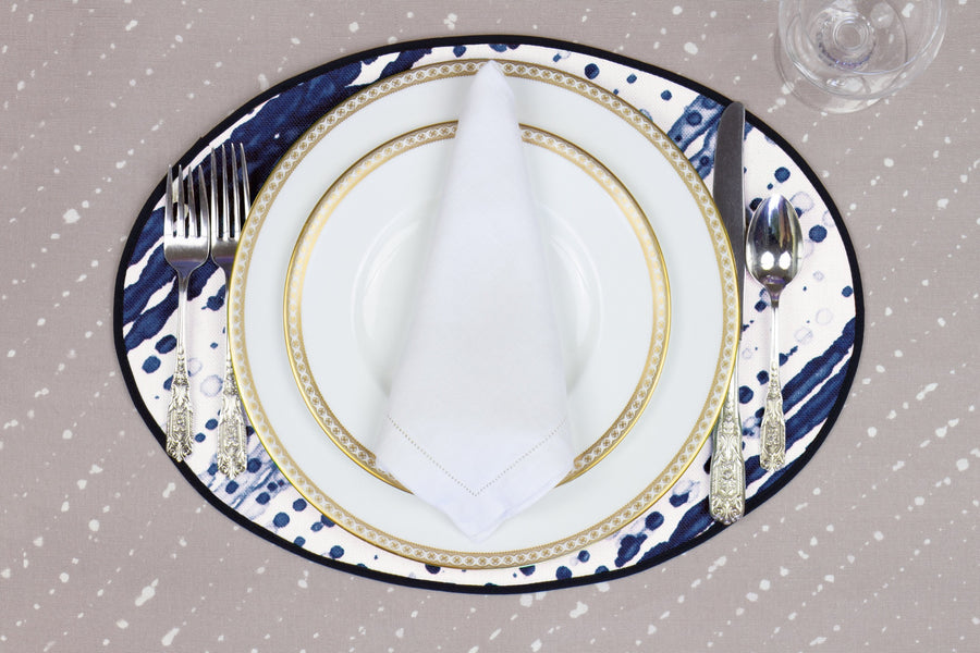 Place setting with 100% linen glissando shibori marine blue placemat on flax shibori linen with white plates
