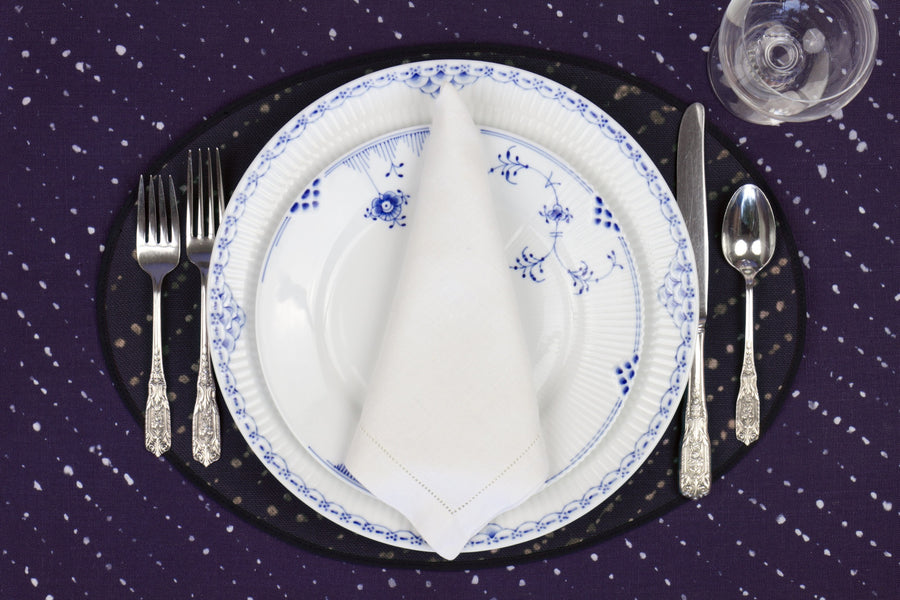 Place setting with 100% linen staccato decolorato shibori midnight blue placemat on linen with blue & white plates