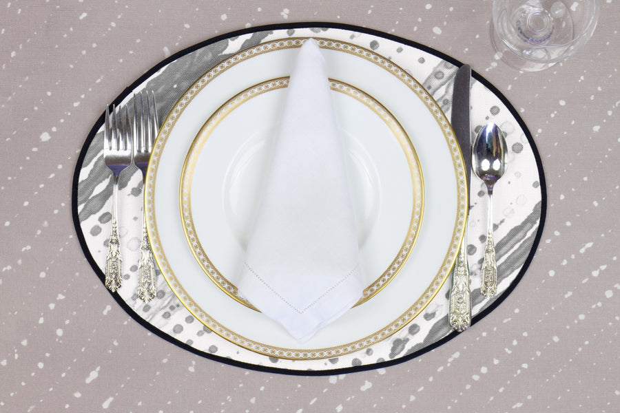 Place setting with 100% linen glissando shibori storm grey placemat on flax shibori linen with white plates