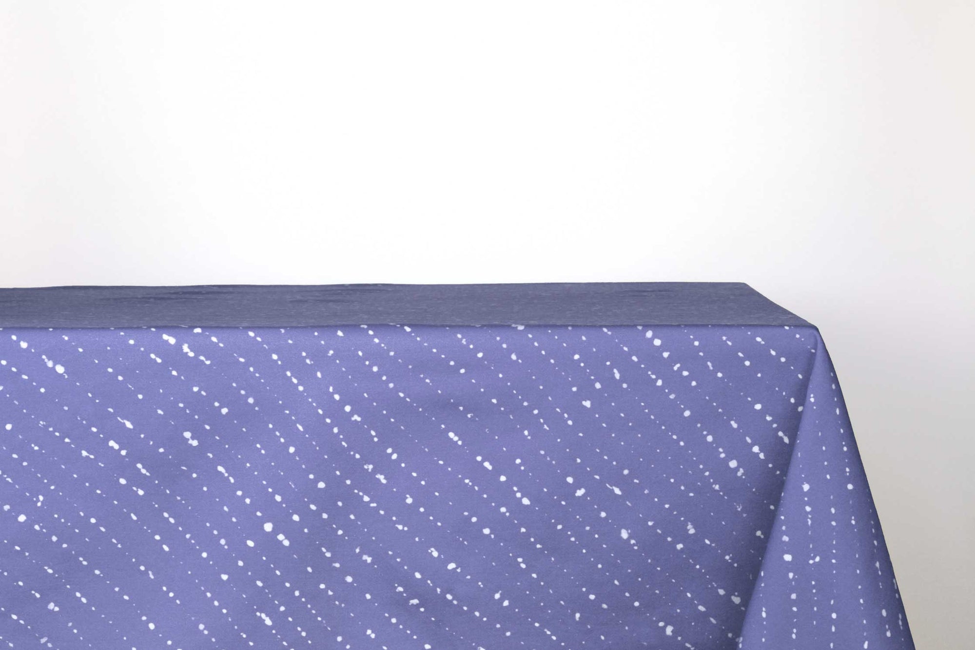 Staccato sbiancato shibori 100% cotton tablecloth in clear cornflower blue on table against a white background