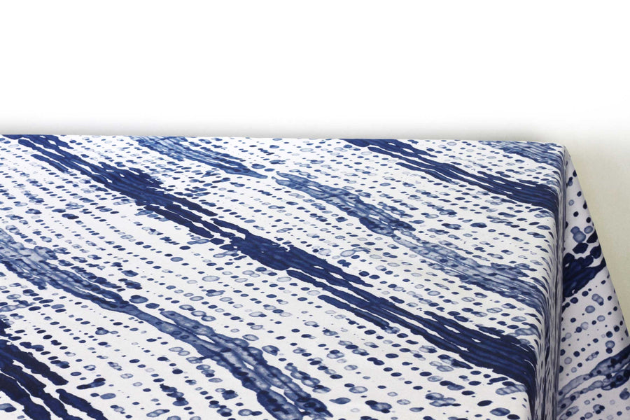Glissando  shibori 100% cotton tablecloth in navy marine blue on table corner view against a white background
