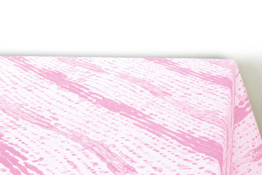 Glissando  shibori 100% cotton tablecloth in delicate posy pink on table corner view against a white background