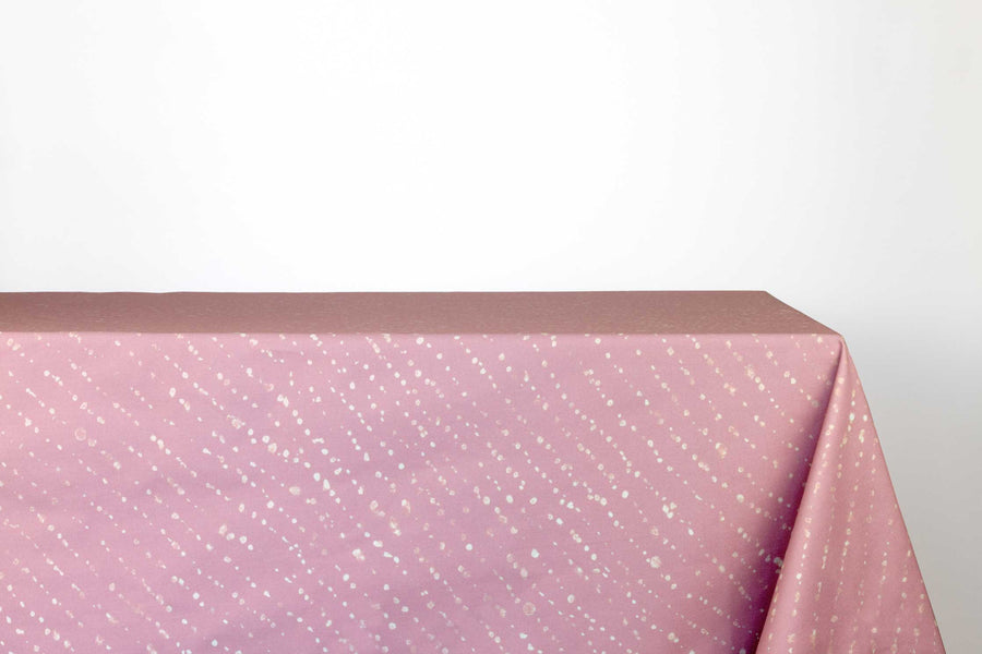Staccato decolorato shibori 100% cotton tablecloth in dusty rose clay pink on table against a white background