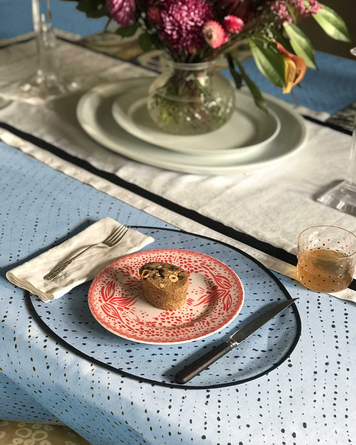 Venable Moore Tabletop Collection with Staccato Nero Shibor in Sky Blue tablecloth and placemat with Mosaic Garden plate in pale orchid and hand-painted confetti glass on table with dessert and flowers 