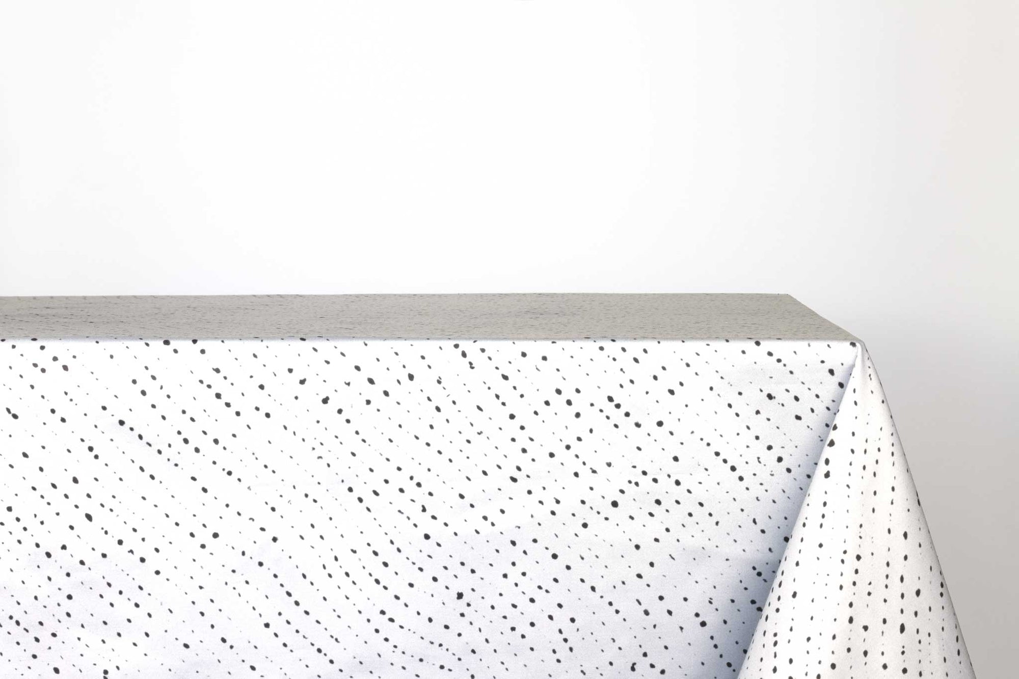 Venable Moore Staccato Nero shibori 100% cotton tablecloth in creamy alabaster white on table against a white background 