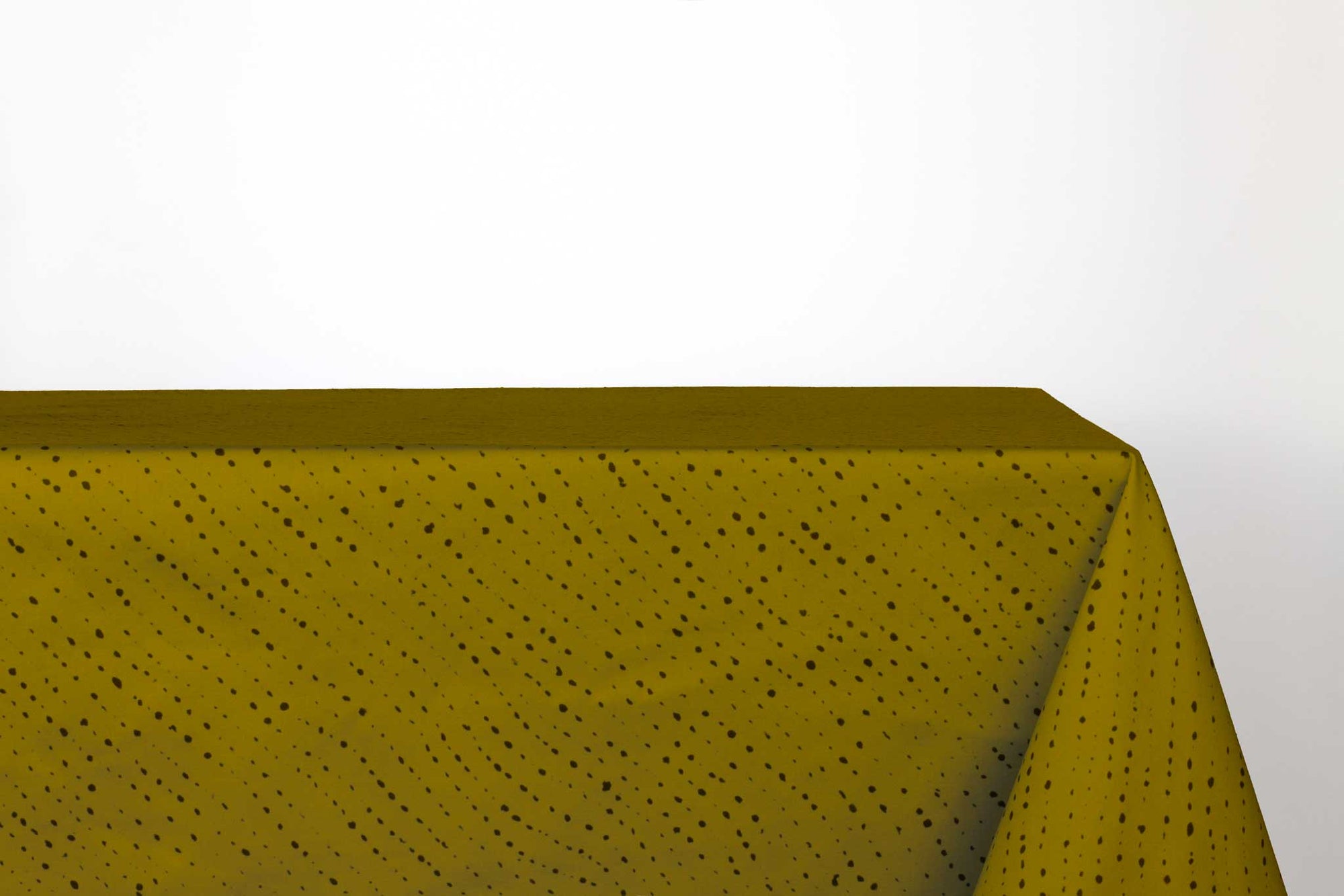 Venable Moore Staccato Nero shibori 100% cotton tablecloth in grounding moss green on table against a white background 