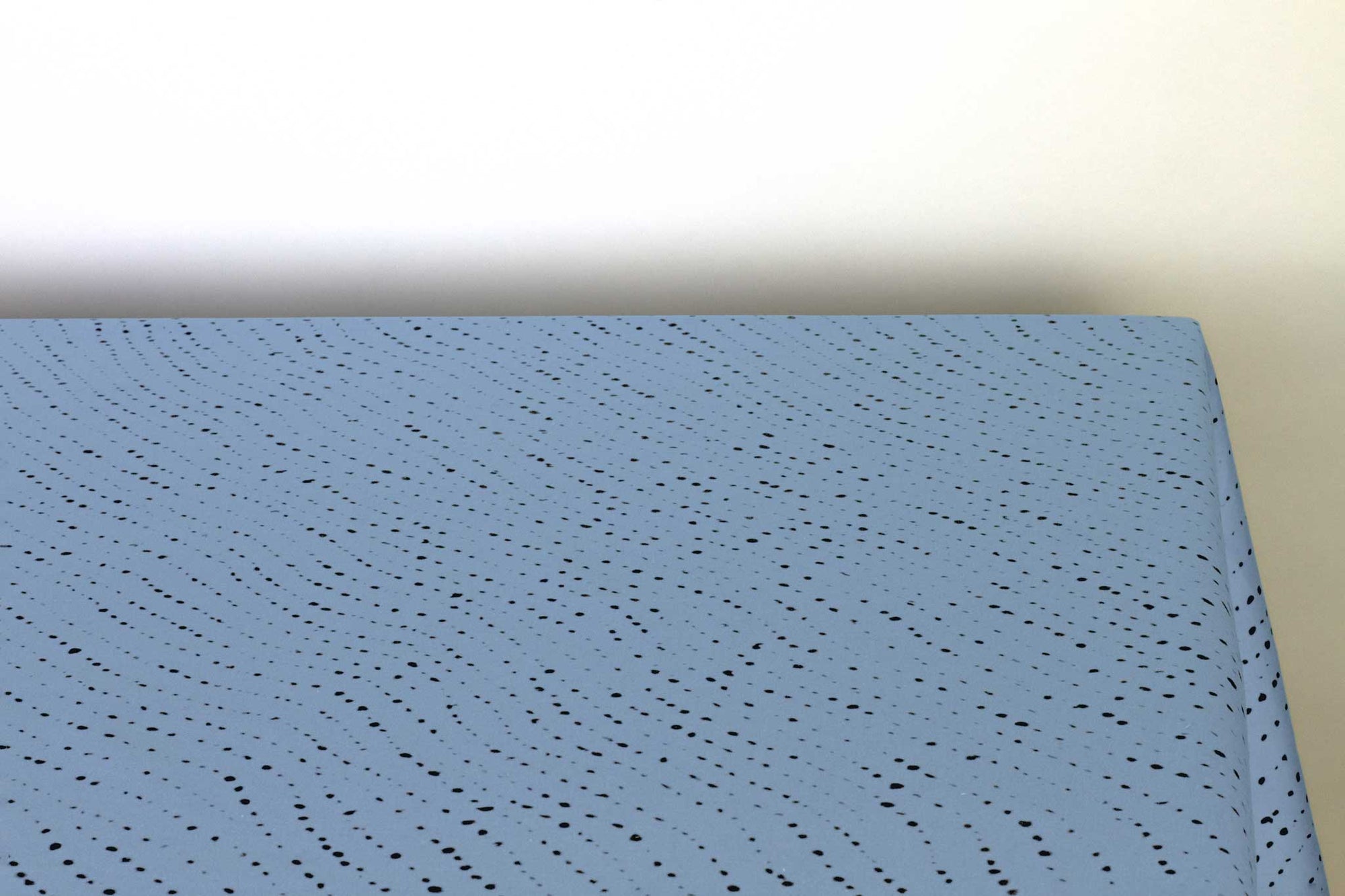Venable Moore Staccato Nero shibori 100% cotton tablecloth in clear sky blue on table corner view against a white background