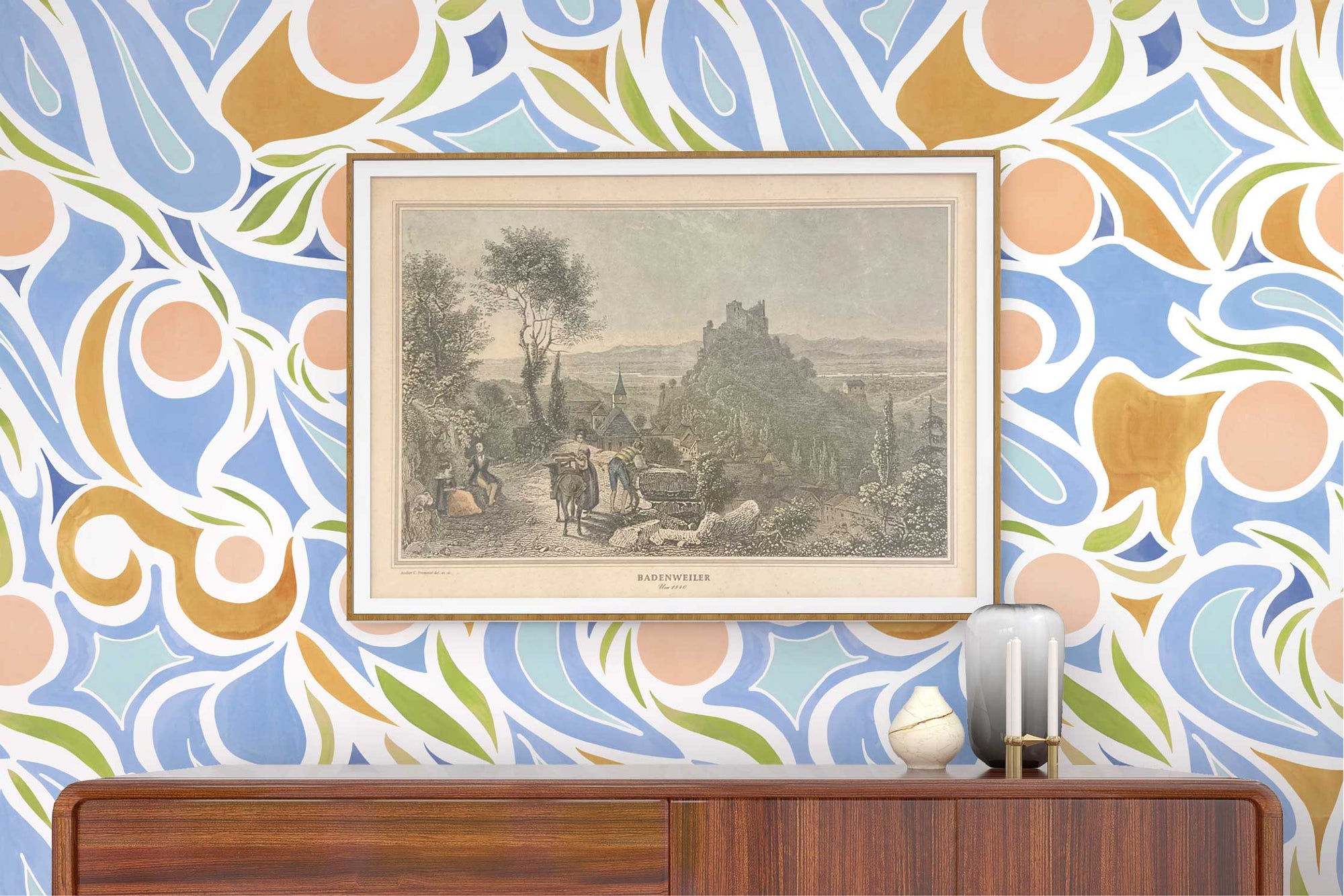 Venable Moore ‘Capri’ Pastel Peach Pink, Blue, and Tan made-to-order, printed in the U.S.A. wallpaper on a wall with wood console, vases, and framed art