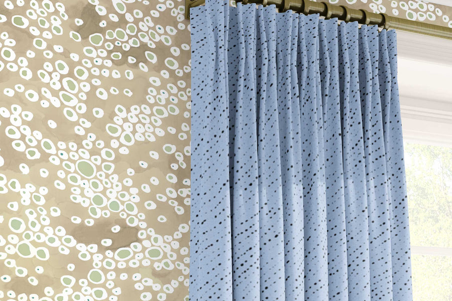 Venable Moore ‘‘Frizzante’ neutral buff tan made-to-order, printed in the U.S.A. wallpaper on a wall with 100% European linen “Staccato Nero’ Shibori curtains in sky blue and window 