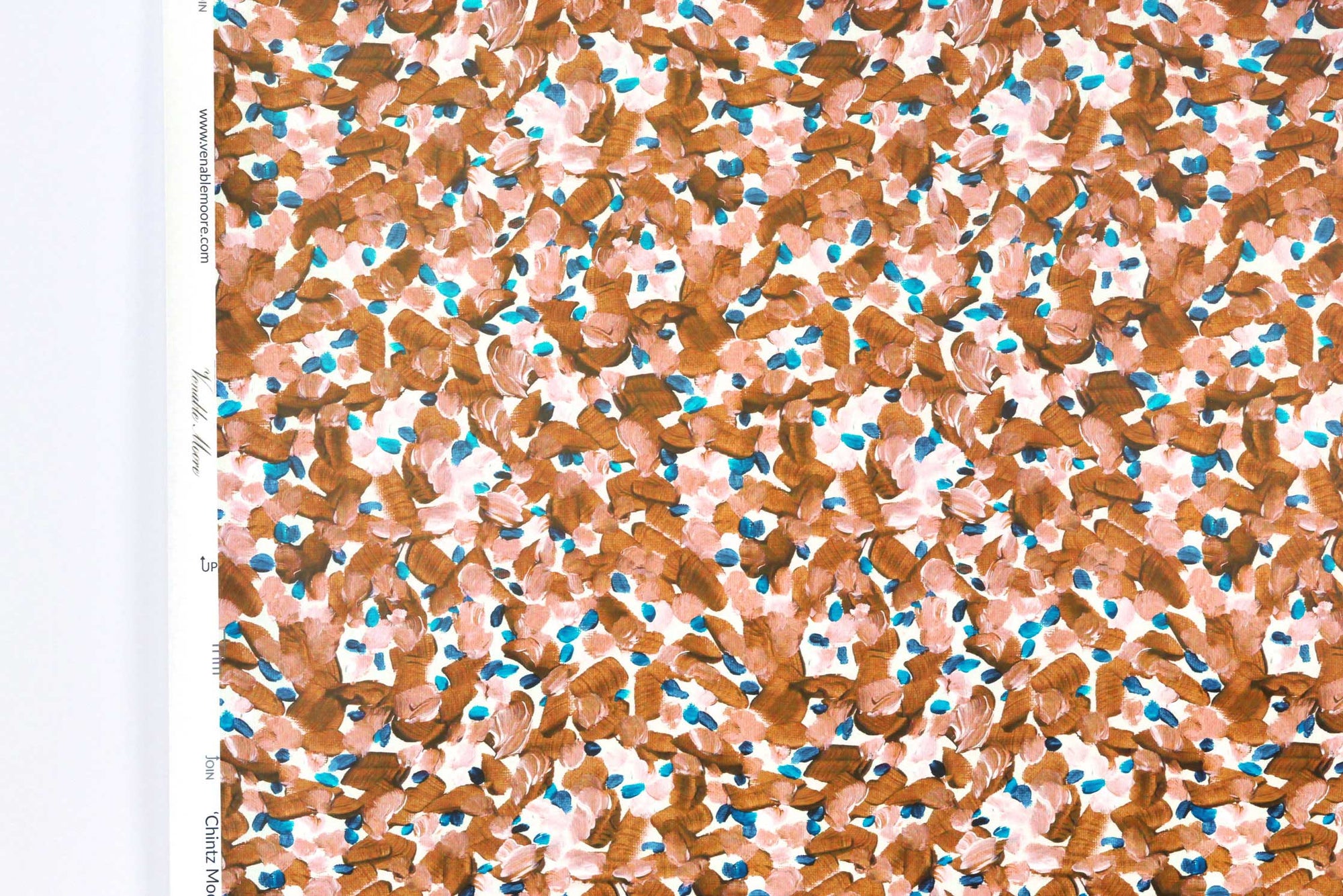 Up close view of Venable Moore Chintz Modern floral abstract in apricot orange, peach, and blue FSC Certified Clay Coated wallpaper roll against a white wall