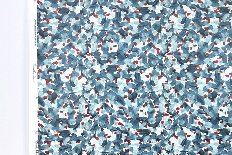 Up close view of Venable Moore Chintz Modern floral abstract in tropical turquoise blue, red, and white FSC Certified Clay Coated wallpaper roll against a white wall