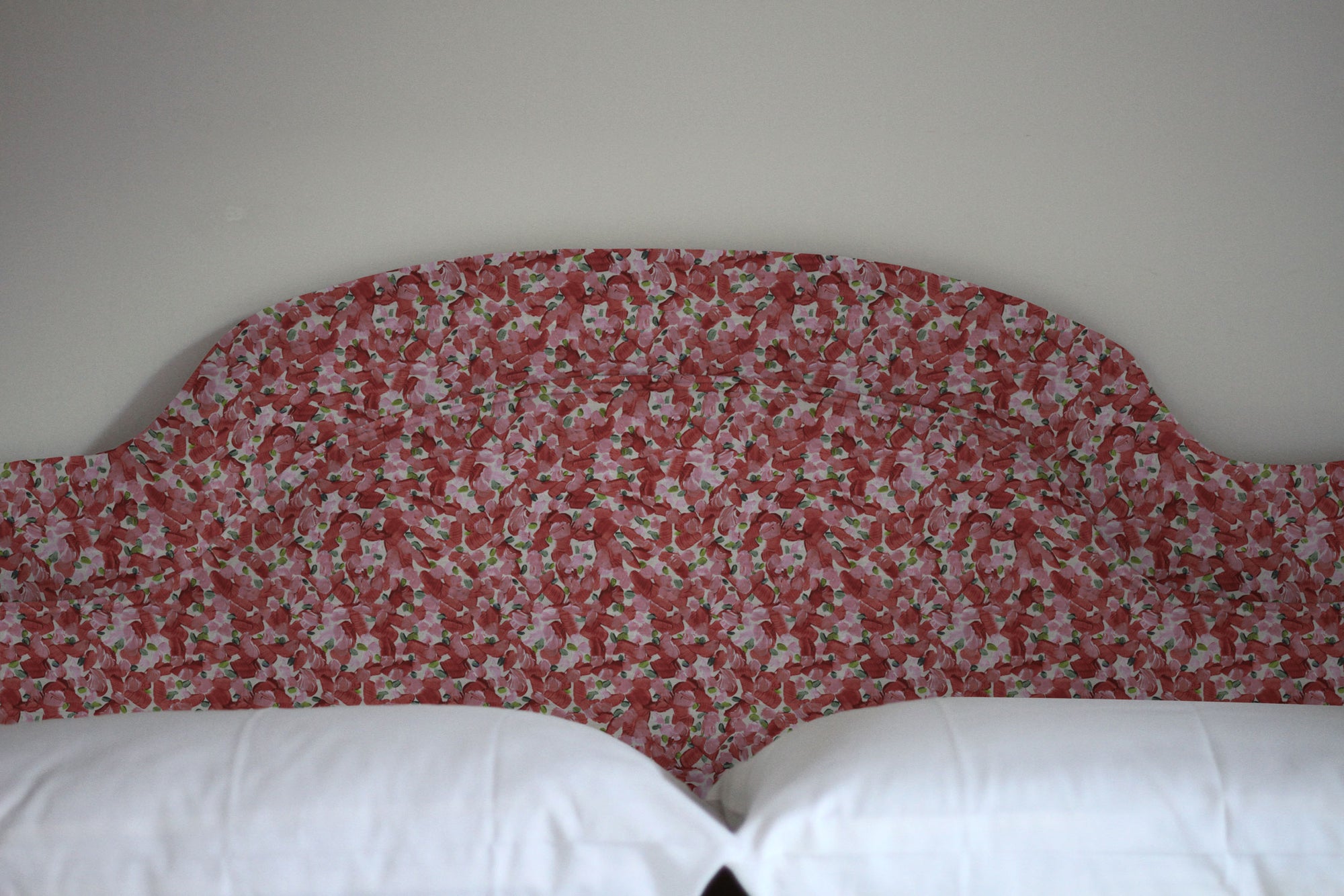 Chintz Moderne floral cotton in cherry upholstered on a headboard and installed in a bedroom