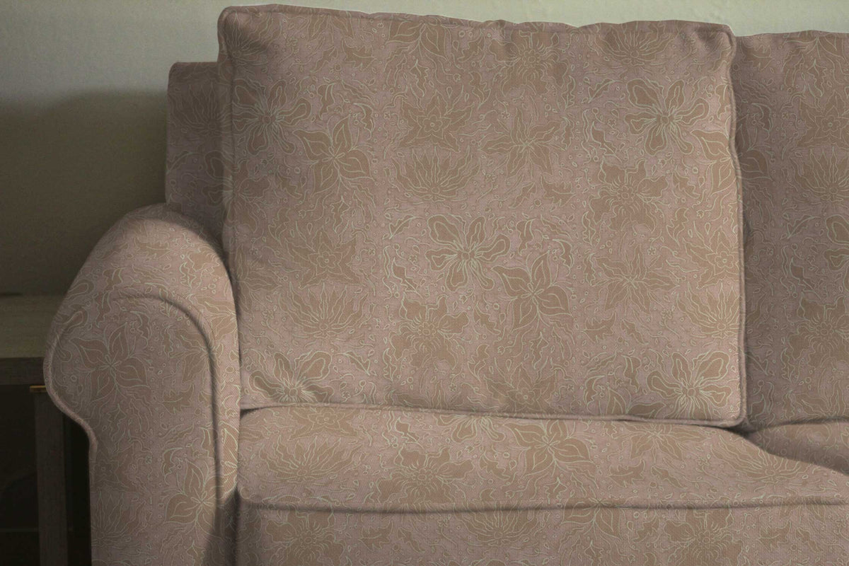 Fiori hand drawn floral cotton fabric in neutral nude upholstered on a sofa installed in a living room