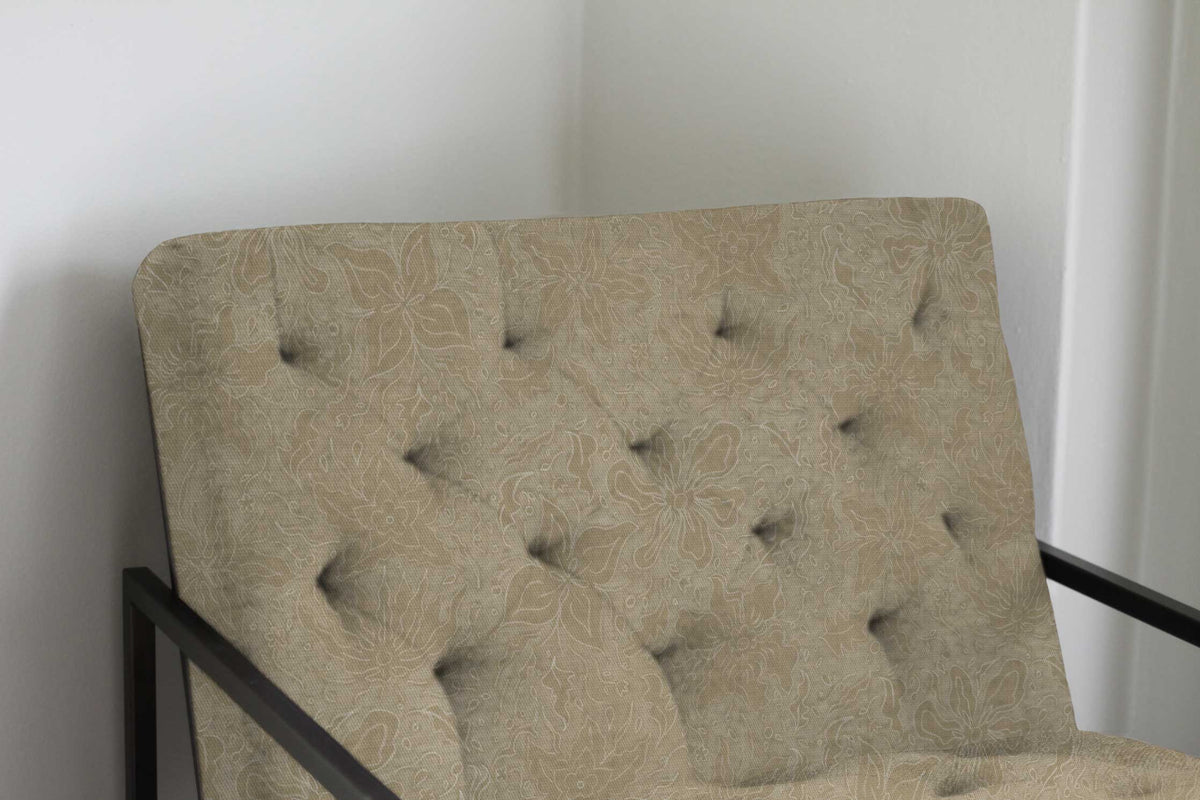 Fiori hand drawn floral cotton fabric in neutral taupe upholstered on a chair against a white wall