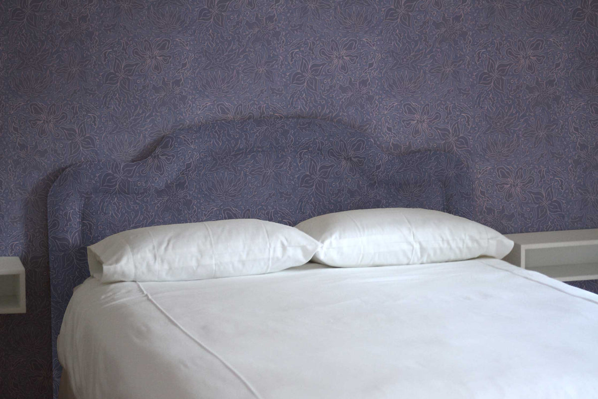 Fiori hand drawn floral wallpaper and fabric installed in a bedroom on the wall and upholstered on a headboard