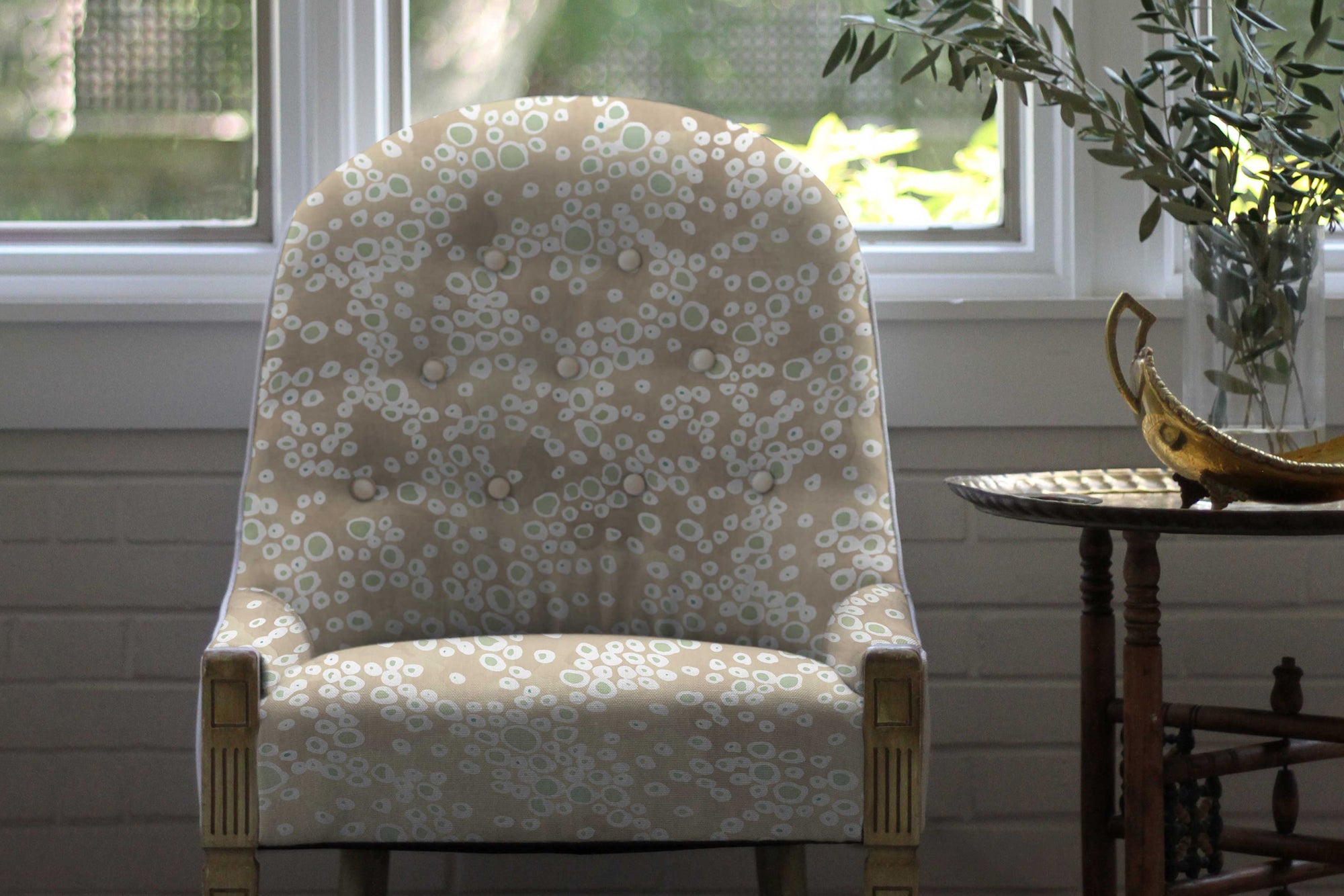 Frizzante hand-painted dotted linen in Buff upholstered on a chair 