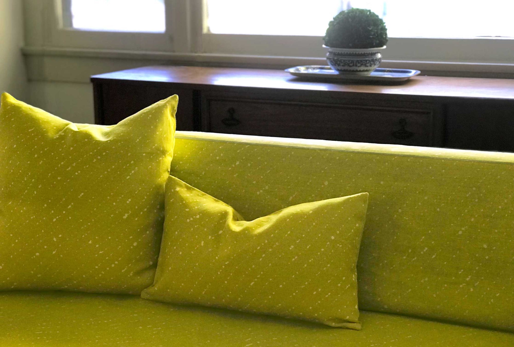 Pear 'Staccato Sbiancato' Shibori linen upholstered on a sofa with pillows in a living room