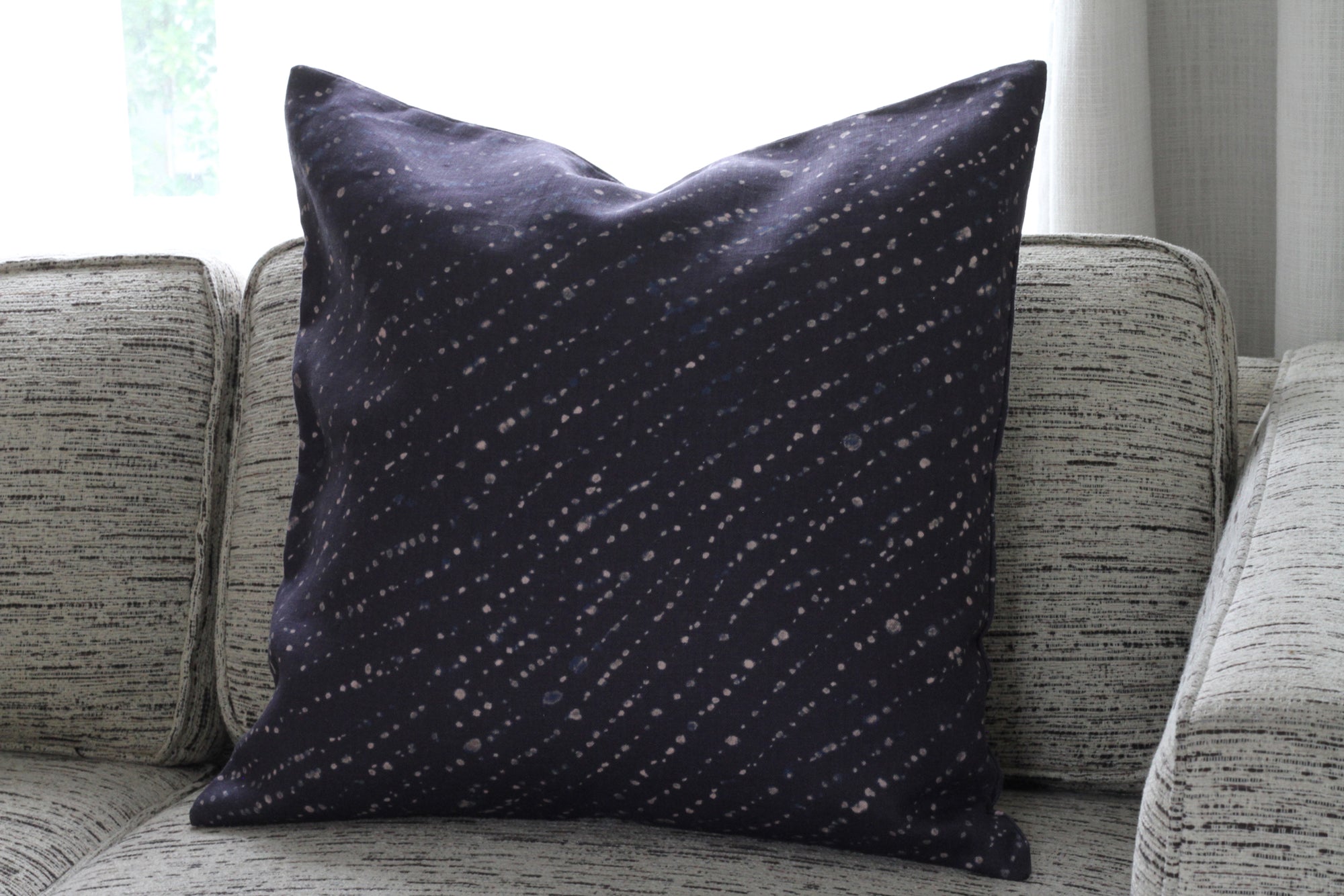 'Staccato Decolorato' Shibori linen pillow in midnight installed on sofa 
