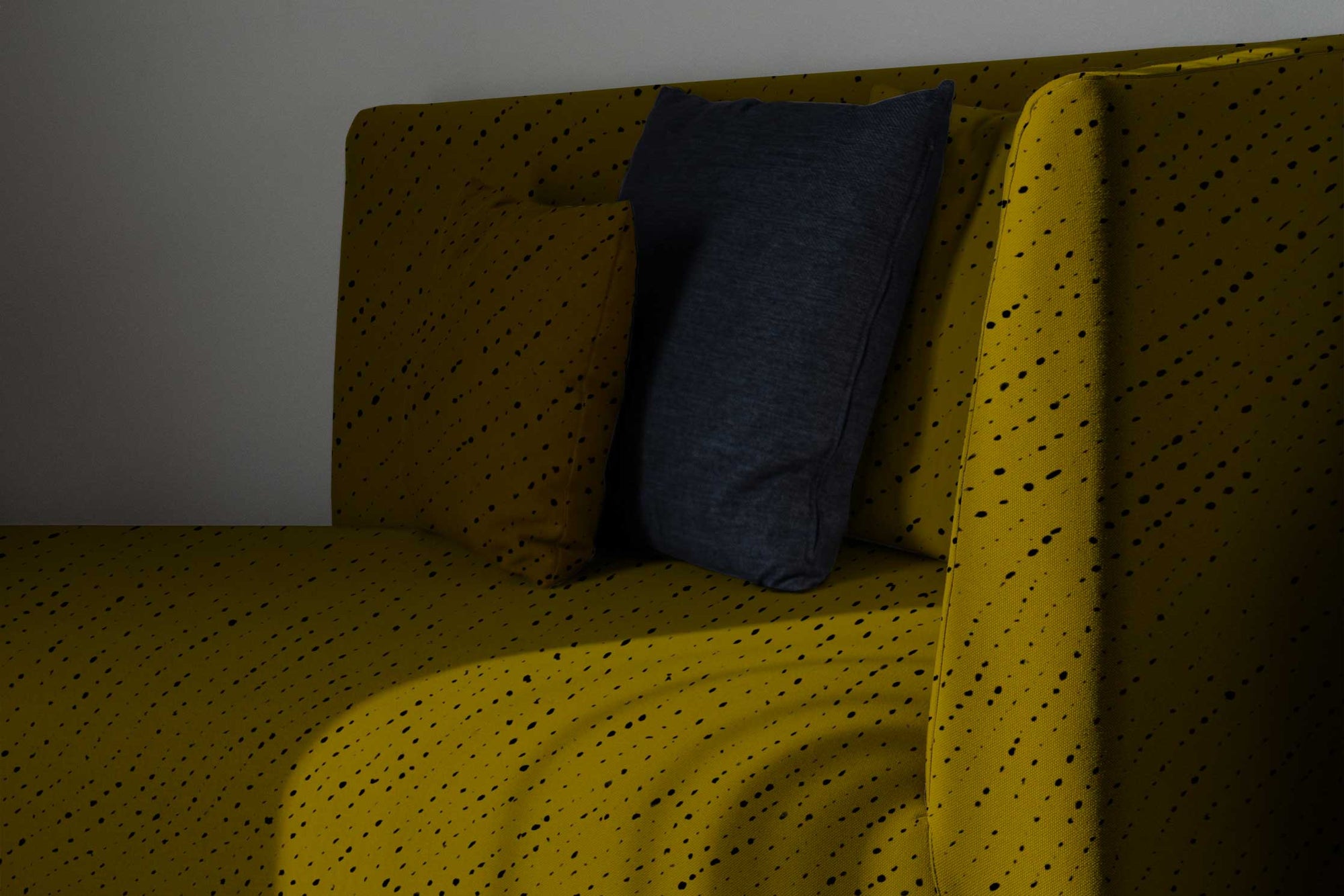 venable moore staccato nero shibori linen in moss upsholstered sofa with pillows against a white wall