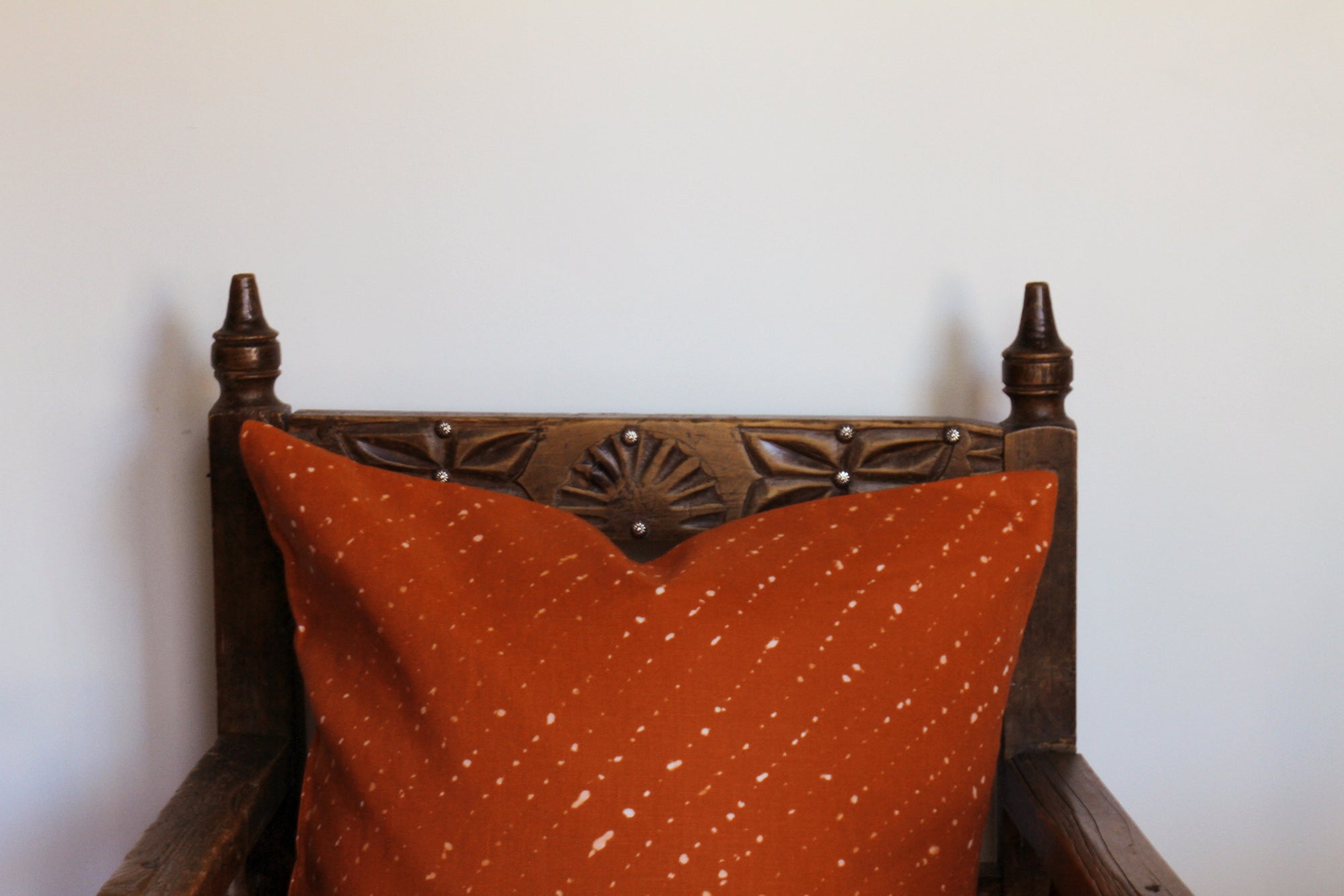 'Staccato Sbiancato' Shibori linen pillow on chair against white wall