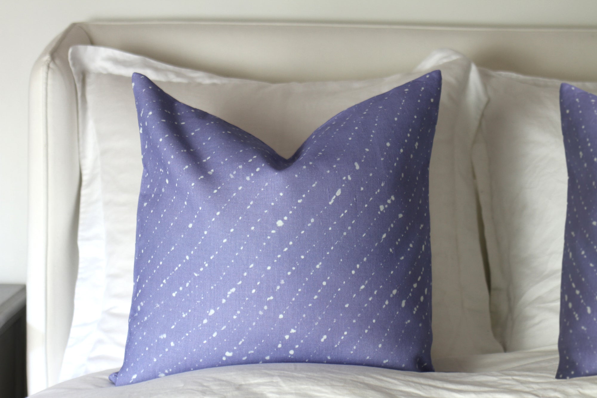 'Staccato Sbiancato' Shibori linen pillows in Cornflower installed on bed