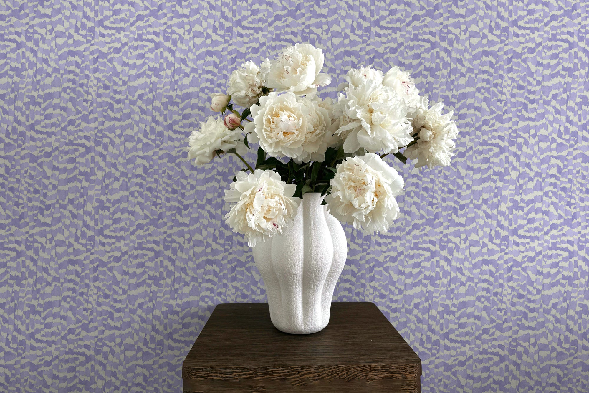 Zebra Stripe wallpaper in lavender installed with pedestal and vase with peonies