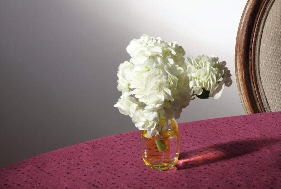 sun yellow hand-painted striped bud vase with hydrangea on cerise pink staccato nero shibori tablecloth in fine linen fabric by the yard