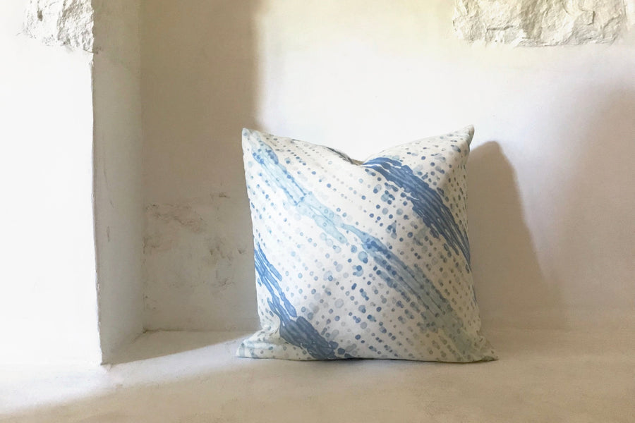 powder blue glissando shibori pillow in fine linen fabric by the yard on a white wall