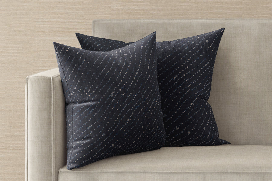 Two 20” x 20” 100% linen reversible staccato decolorato shibori pillows in midnight blue on a sofa 