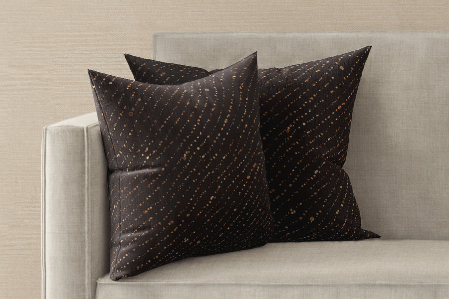 Two 20” x 20” 100% linen reversible staccato decolorato shibori pillows in onyx black on a sofa
