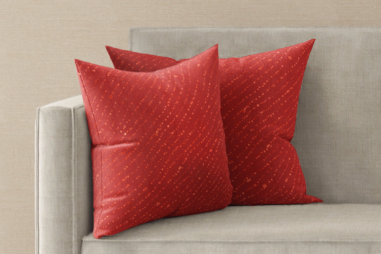Two 20” x 20” 100% linen reversible staccato decolorato shibori pillows in paprika red on a sofa