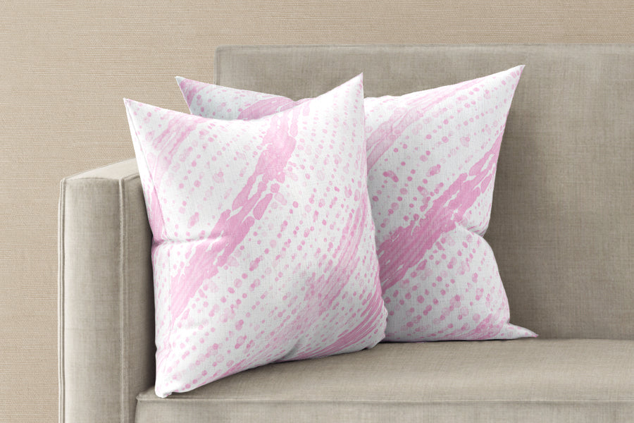 Two 20” x 20” 100% linen reversible glissando shibori pillows in posy pink on a sofa