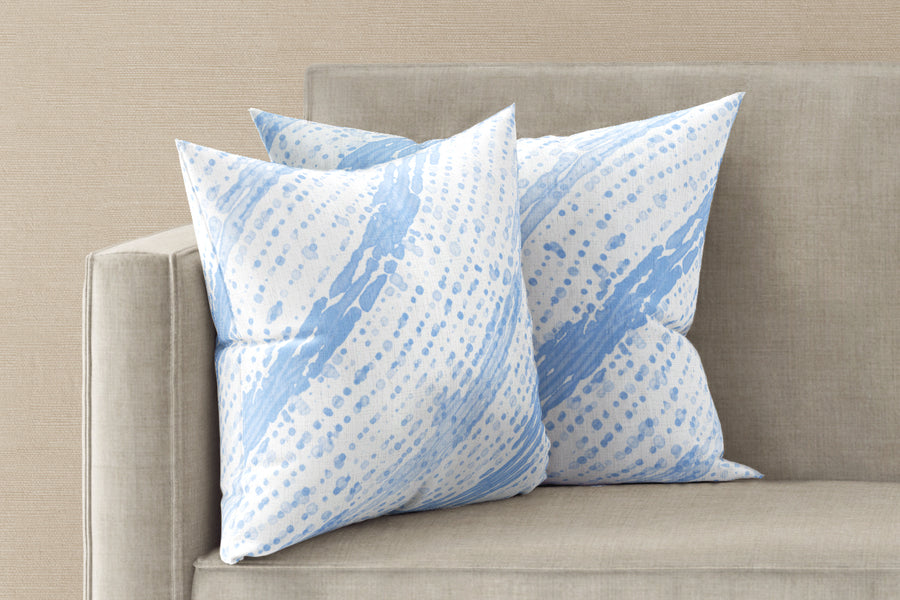Two 20” x 20” 100% linen reversible glissando shibori pillows in powder blue on a sofa
