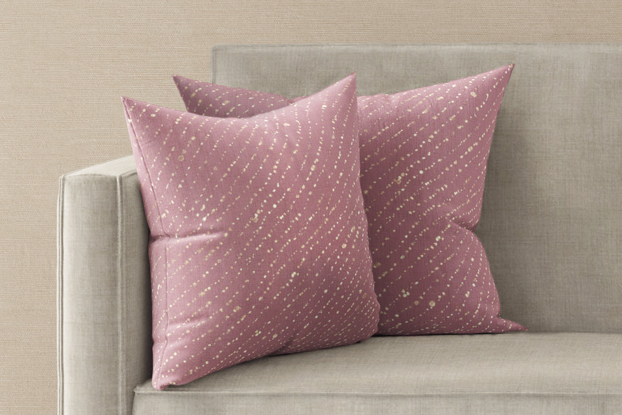 Two 20” x 20” 100% linen reversible staccato decolorato shibori pillows in rose clay pink on a sofa