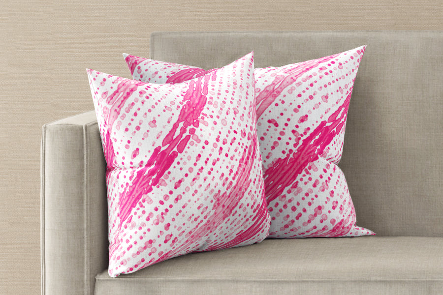 Two 20” x 20” 100% linen reversible glissando shibori pillows in strawberry pink on a sofa