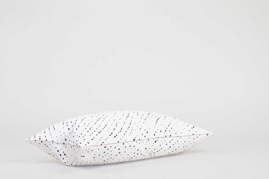 Side view 12” x 20” 100% linen staccato nero shibori pillow in alabaster white with hidden zipper