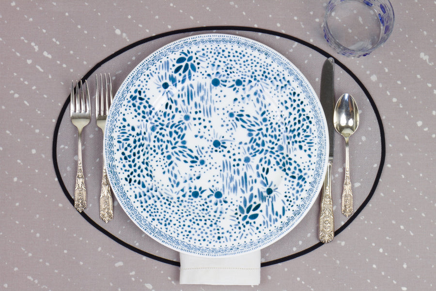 Venable Moore Mosaic Garden dinner plate in blueberry blue with hand-painted Bubble glass on neutral flax tan 'Staccato Sbiancato' Shibori linen placemat and tablecloth with silverware and white linen napkin