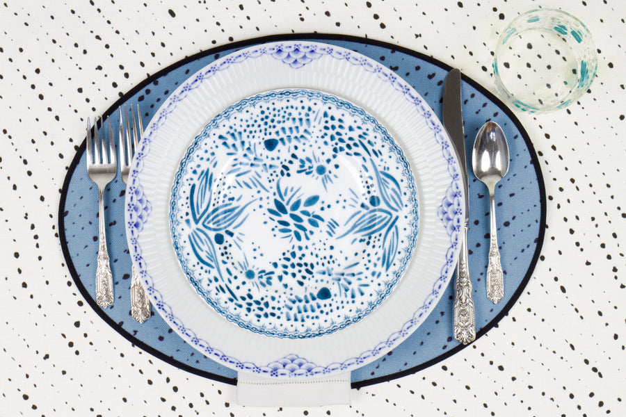 Venable Moore Mosaic Garden salad/dessert plate in fresh blueberry blue on a blue and white plate with hand-painted Bubble glass on sky blue 'Staccato Nero' Shibori linen placemat and alabaster white tablecloth with silverware and white linen napkin
