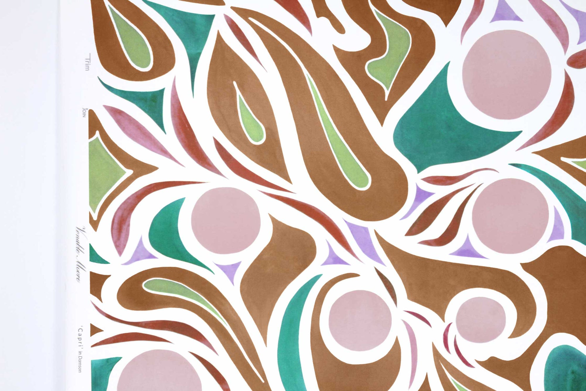 Up close view of Venable Moore ‘Capri’ Damson Plum Purple, Brown, and Teal FSC Certified Clay Coated wallpaper roll against a white wall