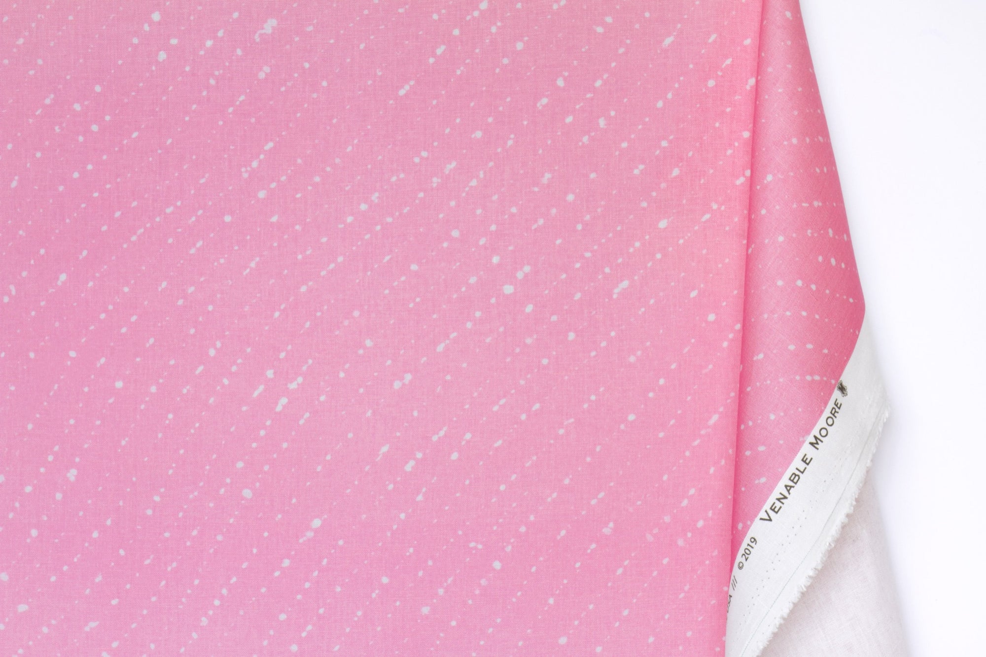 Venable moore 100% european linen staccato sbiancato shibori fabric by the yard with long fold in fresh carnation pink against a white background