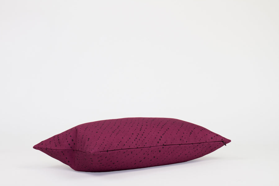 Side view 12” x 20” 100% linen staccato nero shibori pillow in cerise pink with hidden zipper