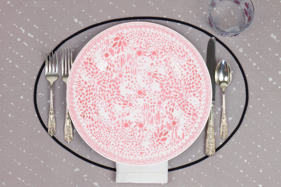 Venable Moore Mosaic Garden dinner plate in grapefruit pink with hand-painted Bubble glass on neutral flax tan 'Staccato Sbiancato' Shibori linen placemat and tablecloth with silverware and white linen napkin