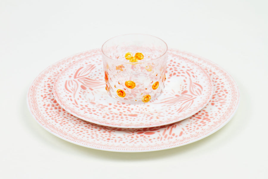 Place setting of hand-painted tangerine glass stacked on grapefruit mosaic garden salad and dinner porcelain plates